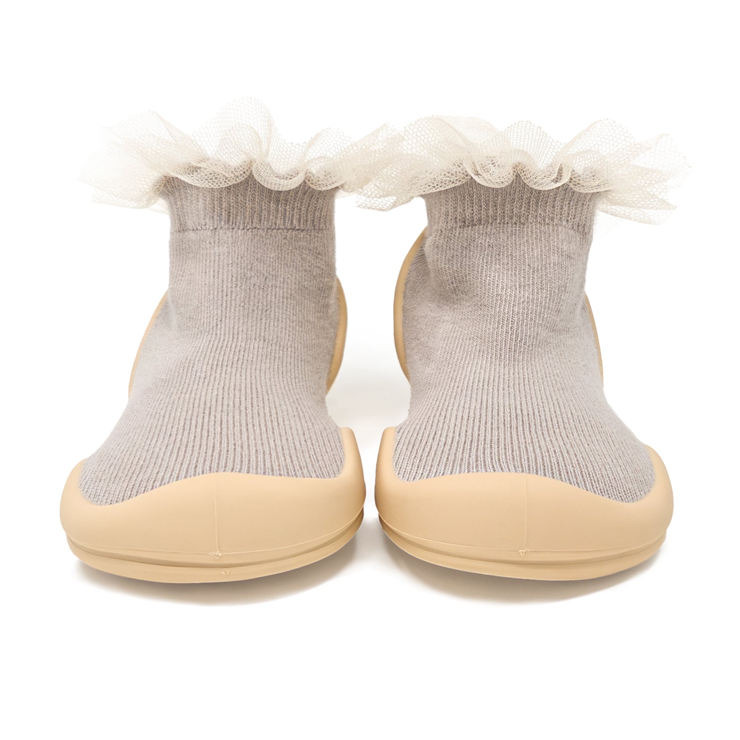 Two gray baby sock-shoes with tan soles and frilly white tulle trim.