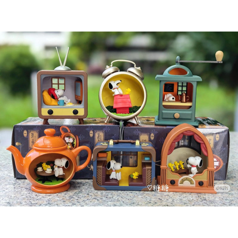 Set of small decorative items featuring cartoon characters on a table with a blurred green background.