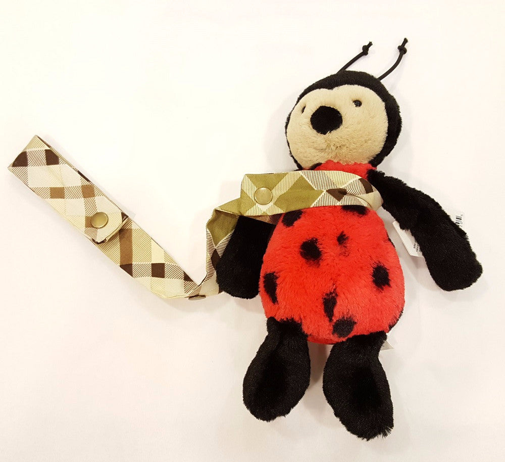 Stuffed ladybug toy with plaid strap.