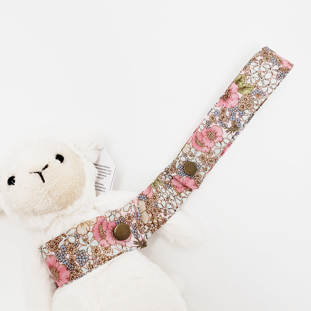 Stuffed lamb with floral strap.