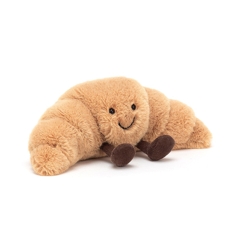Croissant-shaped plush toy with a smiling face and brown corduroy legs.