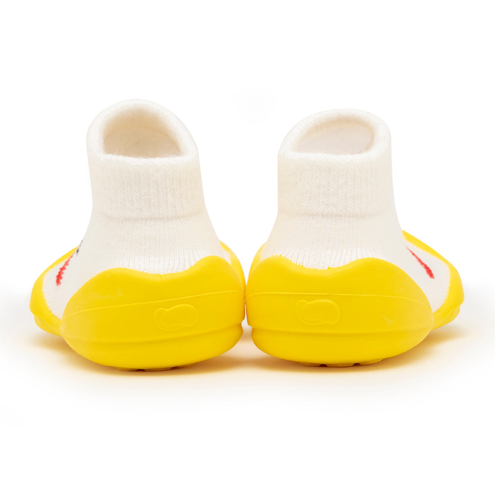 Two baby shoes with yellow soles and white sock-like uppers, viewed from the back.