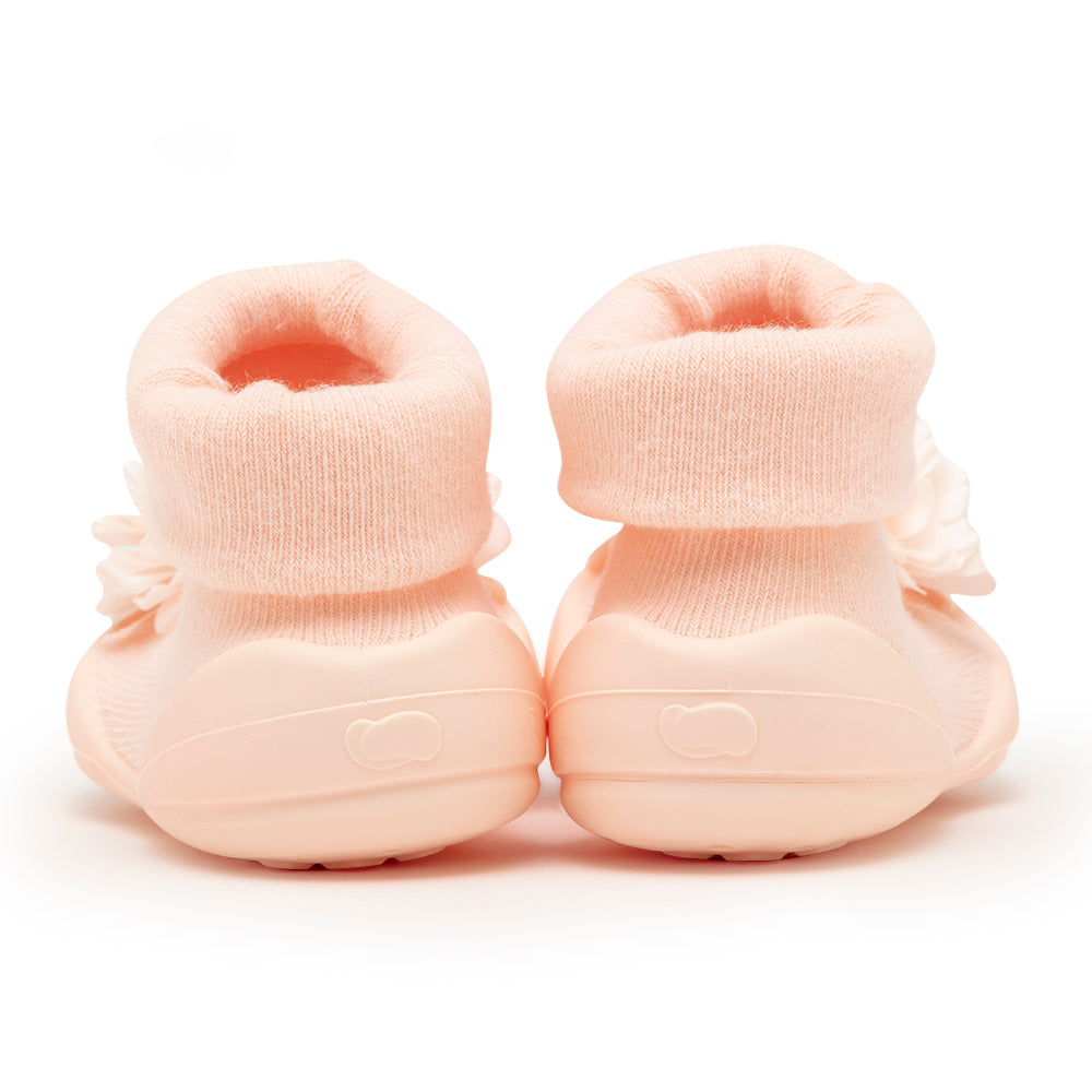 Two peach-colored baby shoes.