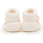 Two baby shoes, off-white, with a flower.