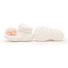 White baby sock shoes with pink flower, sole visible.