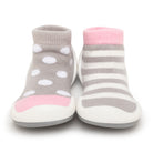 Pair of baby shoes, one with gray and white polka dots, the other with gray and white stripes.