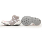 Two baby sock shoes, one with a gray sock with white polka dots and a white sole, and the other showing the gray sole with patterned holes.