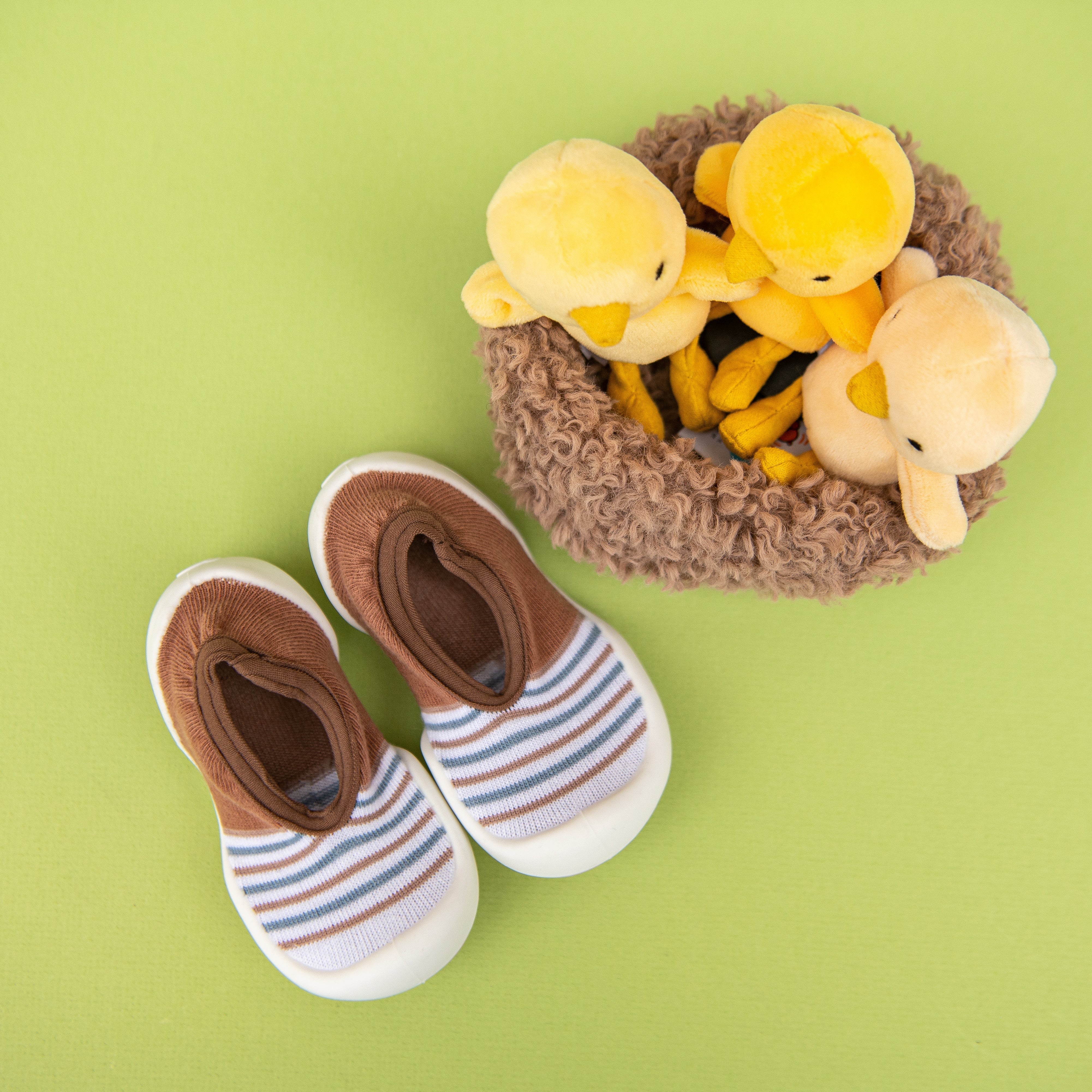 Baby shoes, striped socks, and toy ducklings.