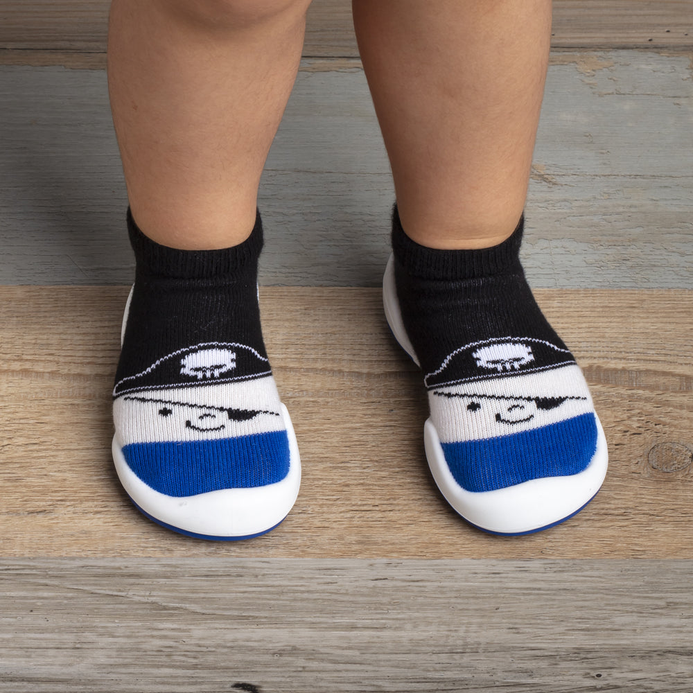 A child wearing black and white sock shoes with a pirate design.