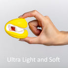 A hand pinches a folded yellow sock, inside the sock is white fabric, and inside the white fabric is red fabric. The background is gray, and the text "Ultra Light and Soft" is visible in white.