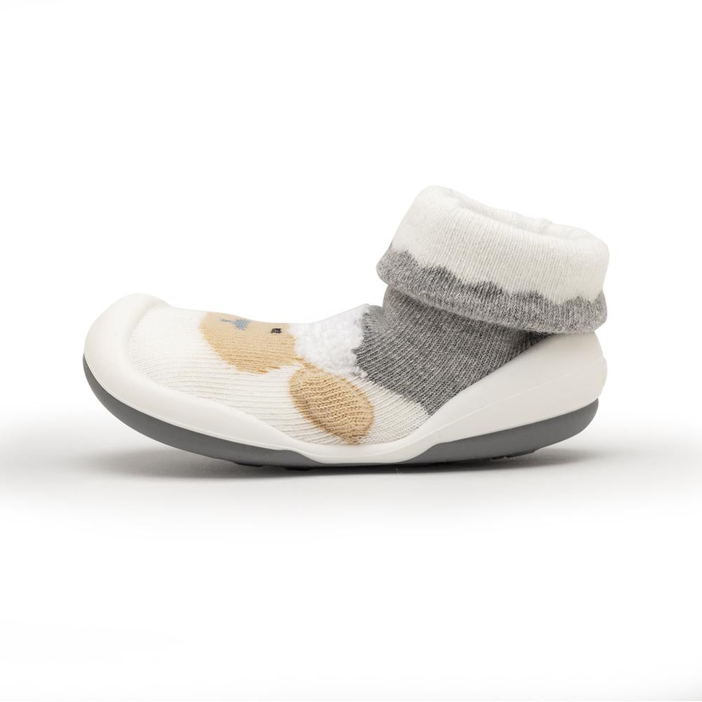 Child's white sock shoe with gray trim and tan animal pattern.