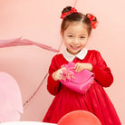 Girl in a red dress with a pink purse.