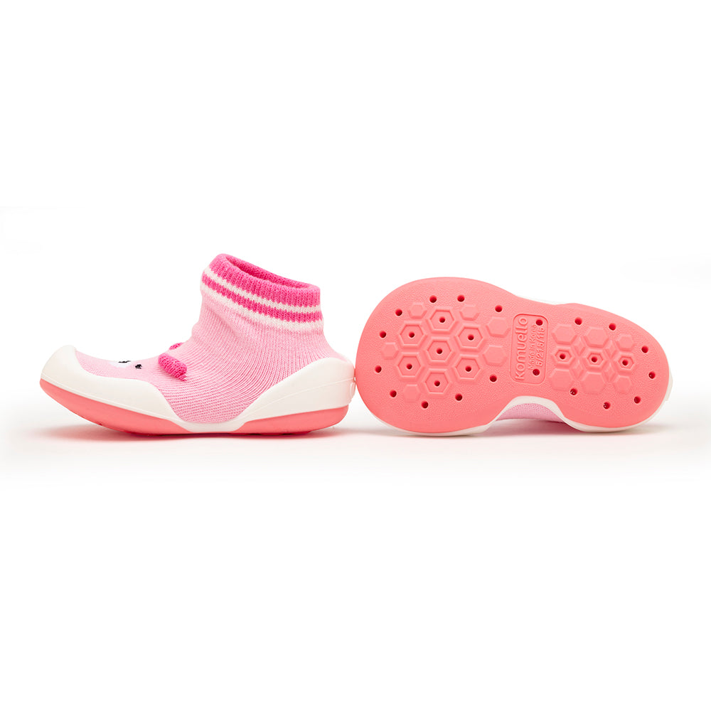 Pair of pink sock shoes, one on its side, one showing sole.