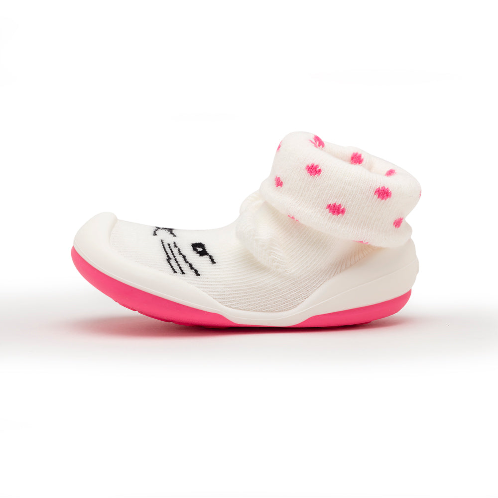 Infant slipper sock with pink sole and polka dots.