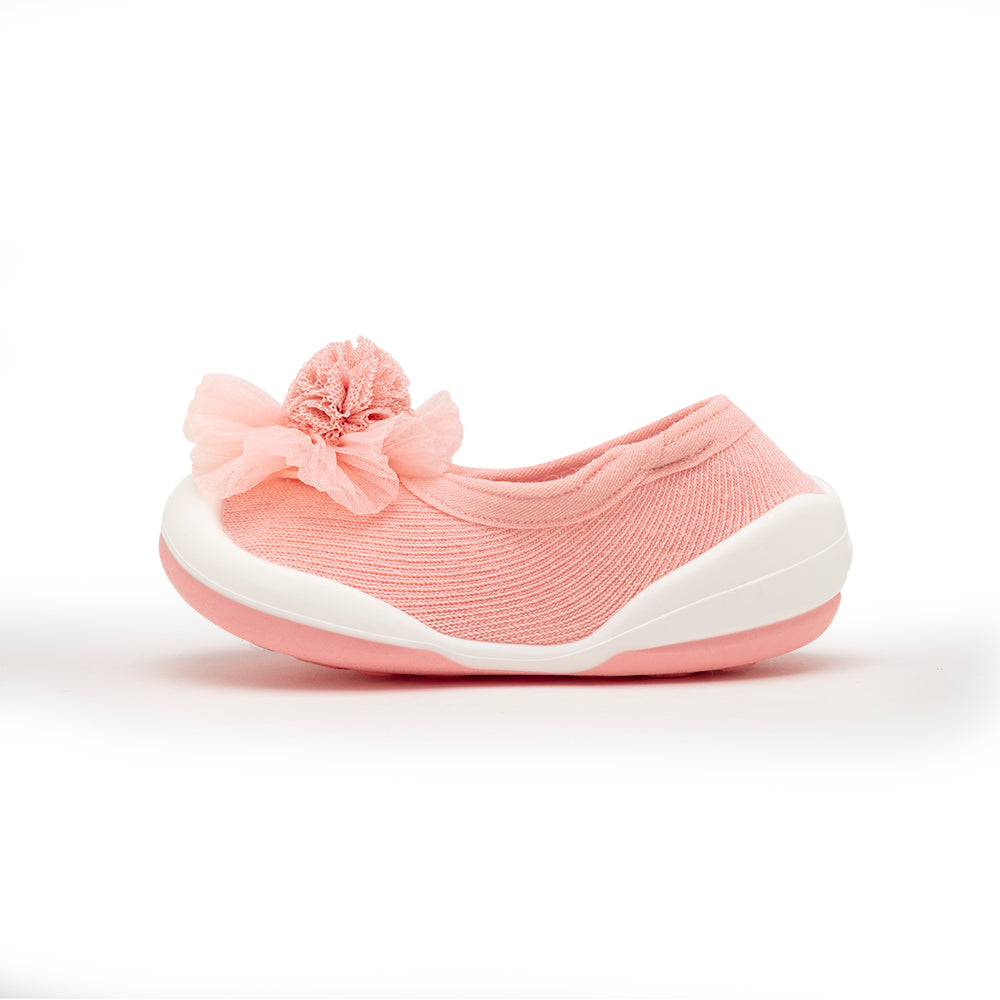 Pink knitted toddler shoe with floral detail.