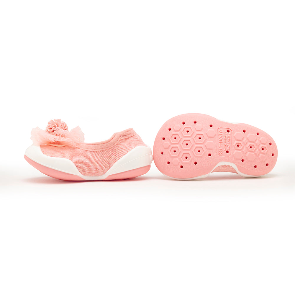 Two pink baby shoes, one with a flower, one showing the sole.