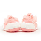 Rear view of pink baby shoes with pom poms and white soles.