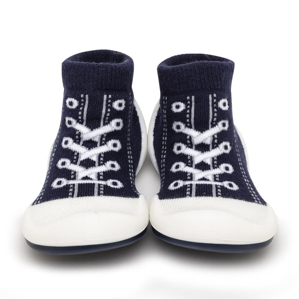 Pair of navy blue baby shoe socks with white laces and soles.