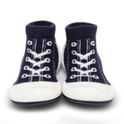 Pair of navy blue baby shoe socks with white laces and soles.