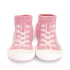 Pair of pink baby sock shoes with white soles.