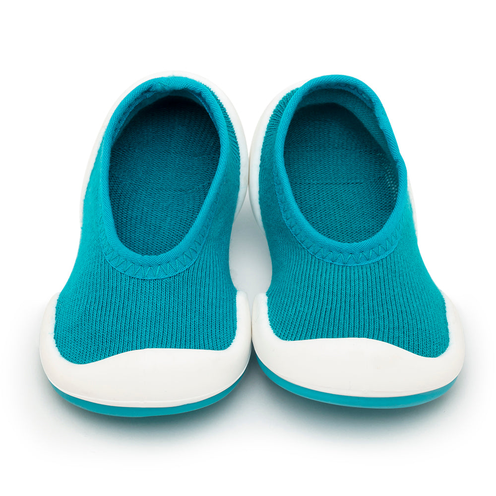 Pair of teal and white knitted baby shoes.