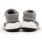 Two baby shoes with gray sock tops and white and black soles.
