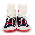 Pair of white baby sock-shoes with red accents and laces.