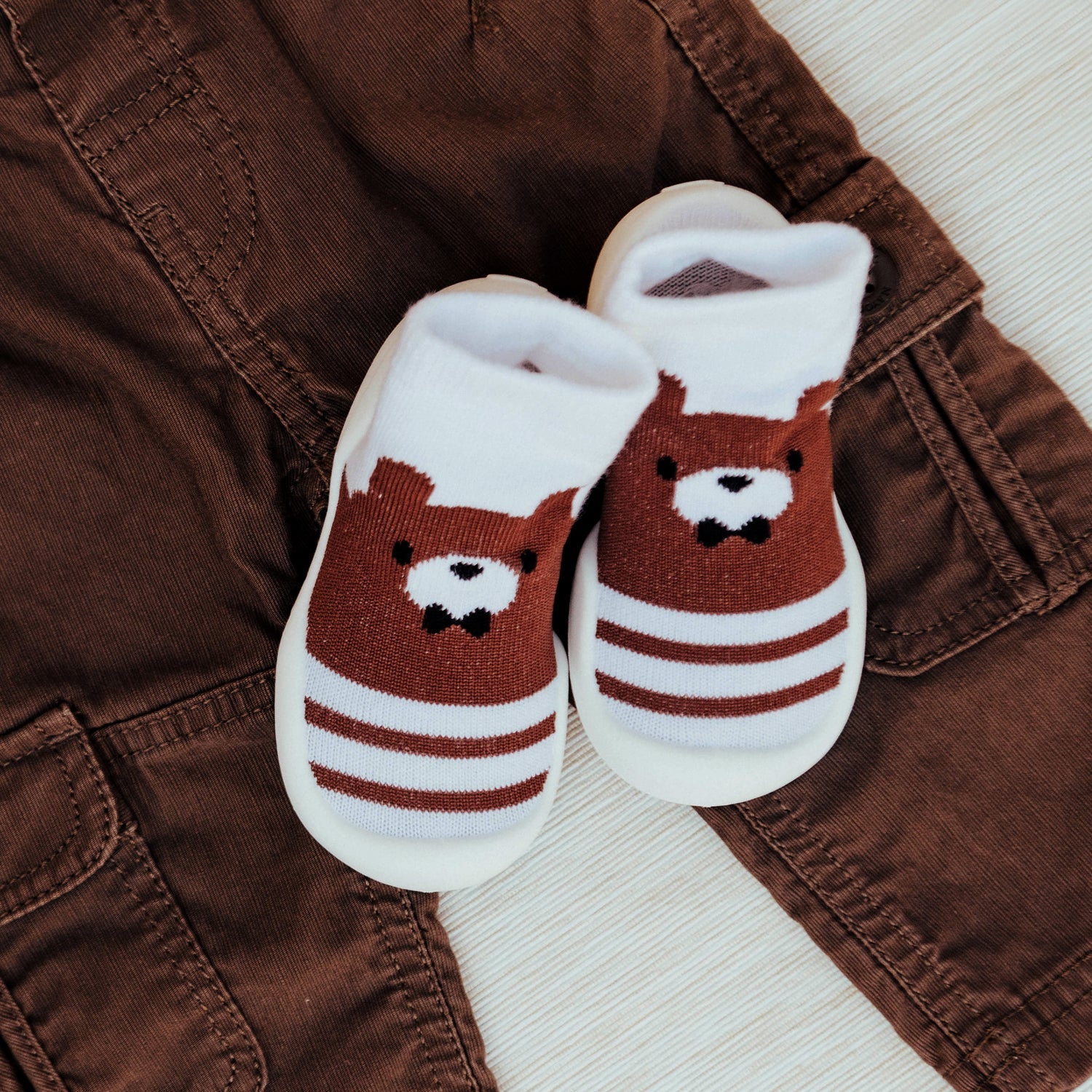 Pair of toddler socks with a bear on brown cargo pants.