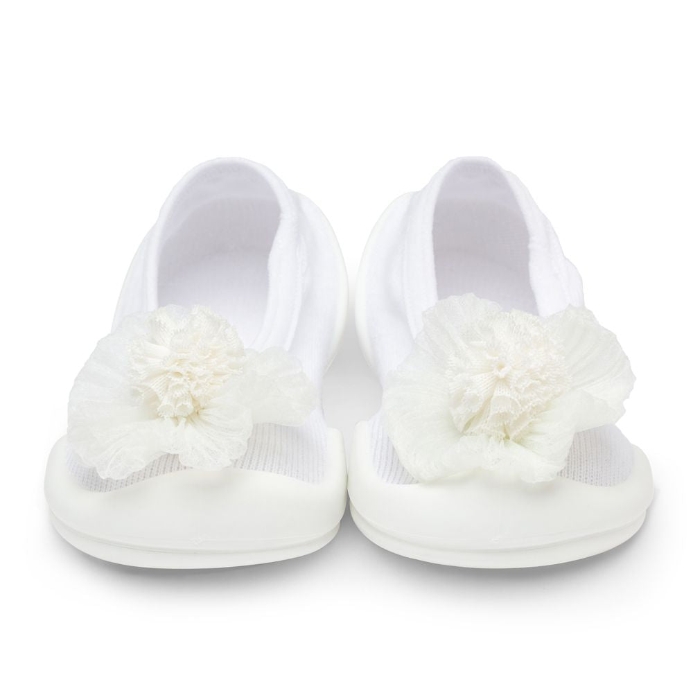 Pair of white baby shoes with flower embellishments.