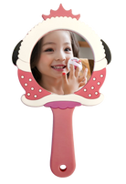Little girl smiling in a handheld mirror while applying makeup.