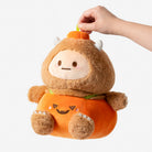 Plush toy resembling a character in an orange outfit with a white background