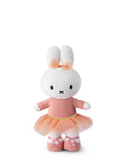 Plush toy rabbit in a pink dress with a bow on a white background