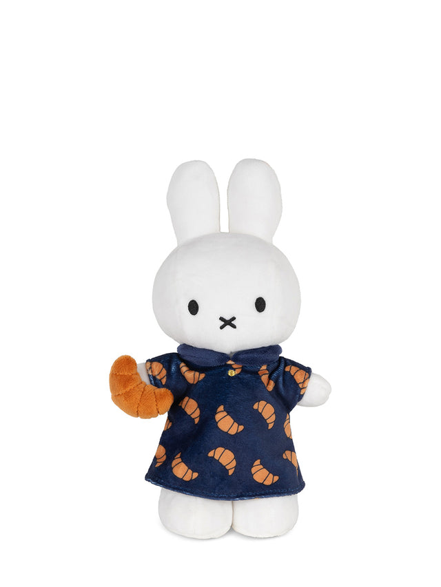 White rabbit plush toy wearing a navy dress with orange patterns on a white background