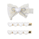 A hair accessory set featuring a white lace bow hair clip with a central white heart and silver ribbon bow, accompanied by two white heart-shaped pearl hair pins with gold metal bases, all displayed on a clean white background.