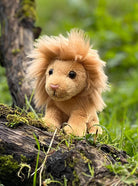 Plush lion toy on a log with a natural background