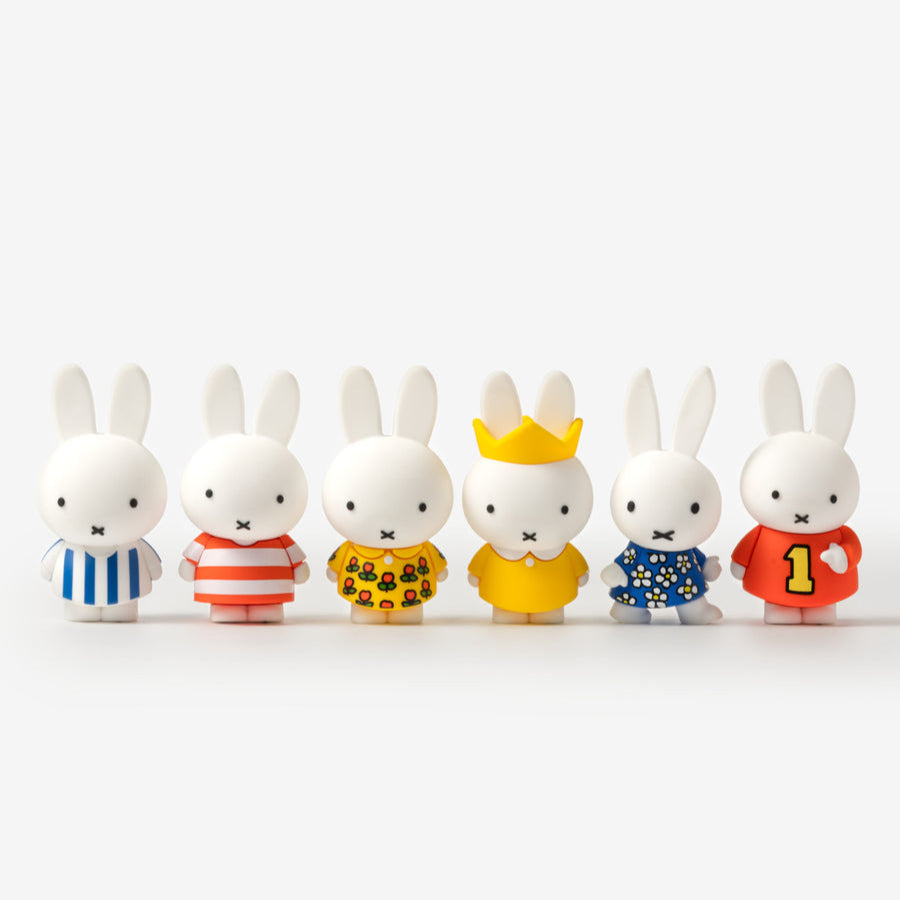Set of small rabbit figurines in various outfits on a white background