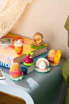 Set of small figurines on books with a soft, neutral background