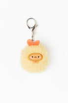 Pom-pom keychain with a face design on a white background