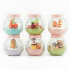 Set of four small glass jars with colorful contents on a white background