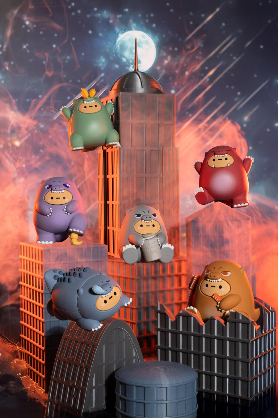 A set of colorful cartoon blob figurines posed on and around stylized gray buildings against a dramatic orange and blue space-themed backdrop with a moon and stars.