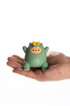 Small green dragon figurine held in a hand against a white background