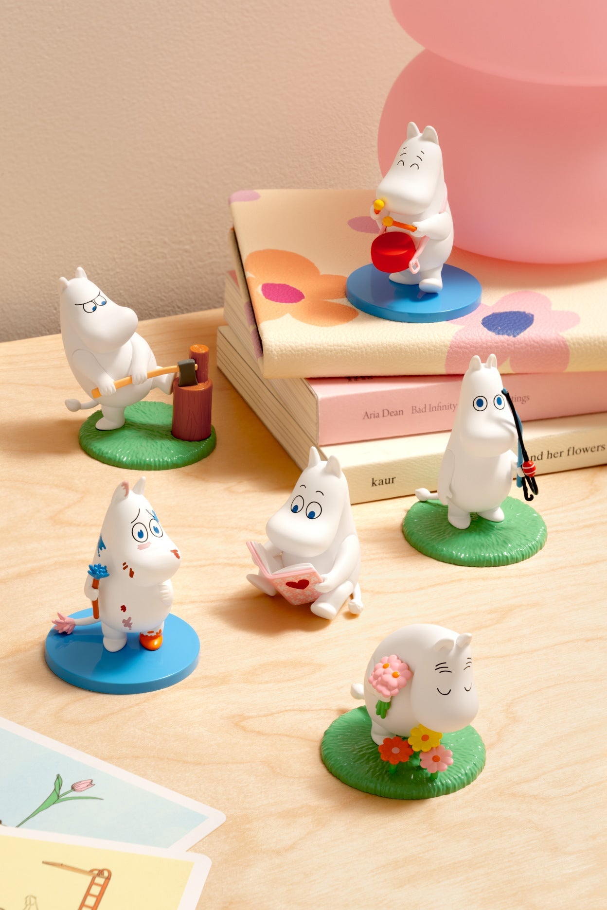 Set of small figurines on a wooden surface with a book in the background
