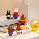 Set of small figurines on a surface with a tissue box in the background