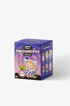 A purple and blue mystery blind box for 'Smoko Switcheroo' featuring cartoon character illustrations, set against a plain light gray background.