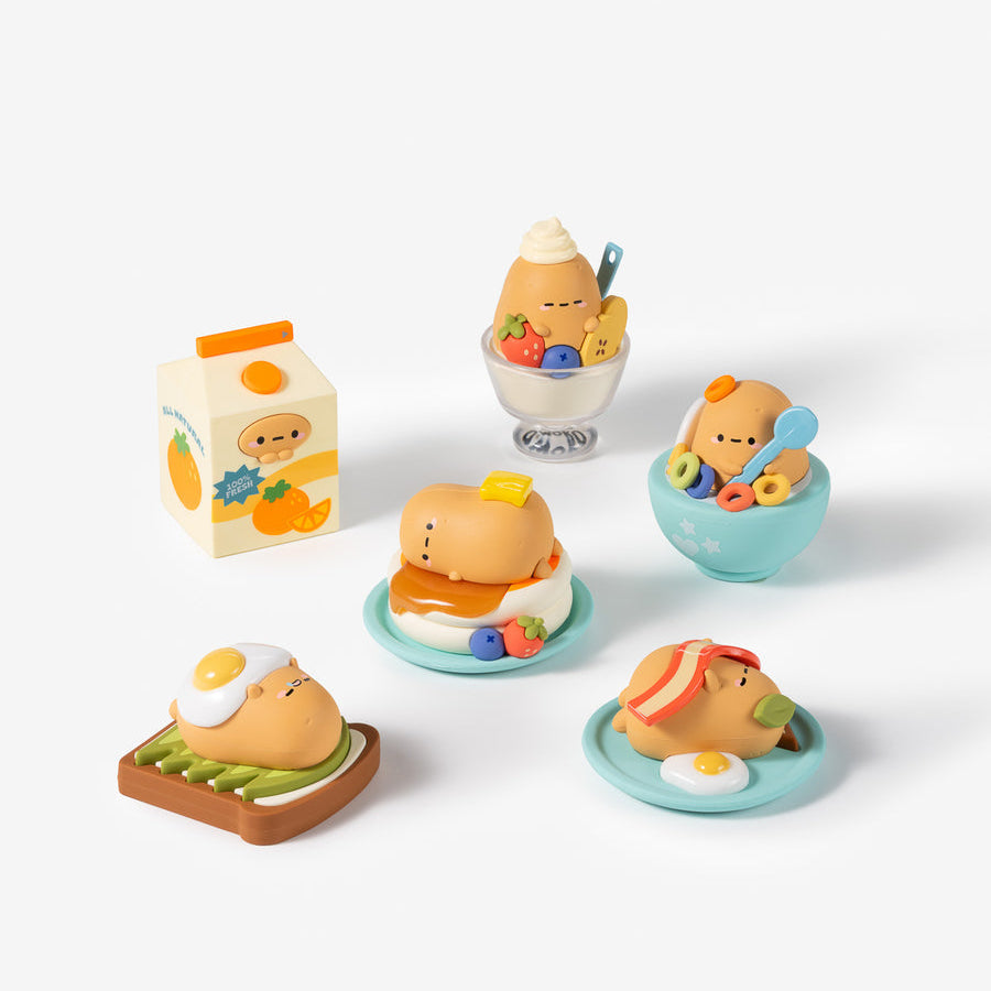 Five small cute breakfast-themed figurines and a milk carton set on a clean white background. The characters have round orange-brown faces and are shown with eggs, toast, a sandwich, a cup with a spoon, and a milk carton.
