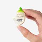 A hand holding a small, cute, garlic-shaped novelty item with the brand name 'SMOKO' printed on the front, set against a plain white background.