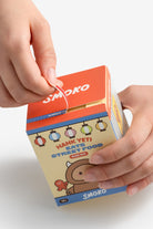 Smoko street food snack box held by a hand on a white background