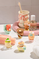 Set of small figurines resembling cartoon characters on a bathroom counter with hygiene products.