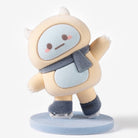 A cute, soft-textured cartoon figurine of a pale yellow creature with a light blue face, wearing a dark gray scarf and boots, standing on a round light blue base against a clean white background.