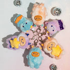Set of colorful plush keychains with cartoon faces on a light background